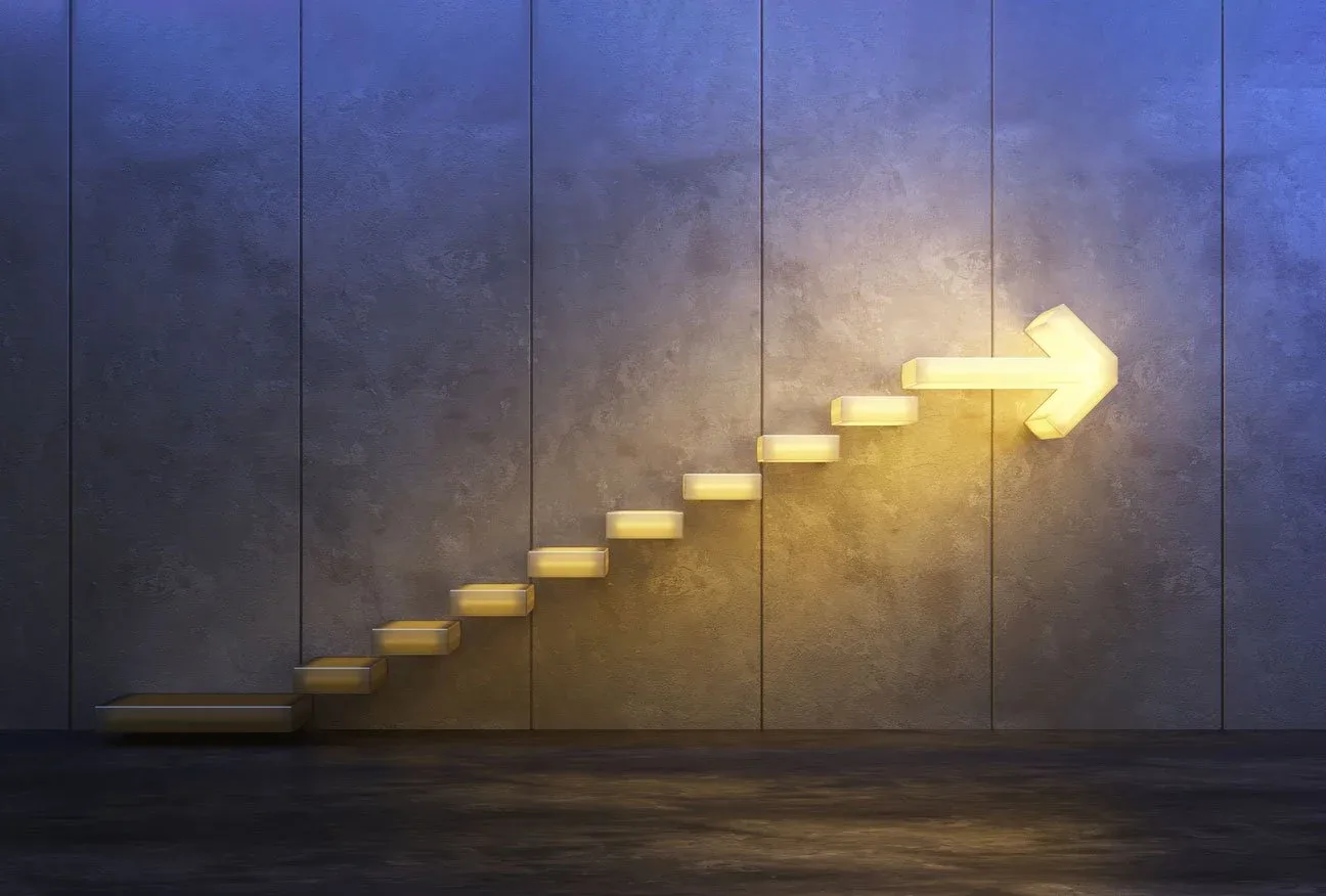 Illuminated wall with a staircase shaped arrow pointing to the right, symbolizing progress or growth.