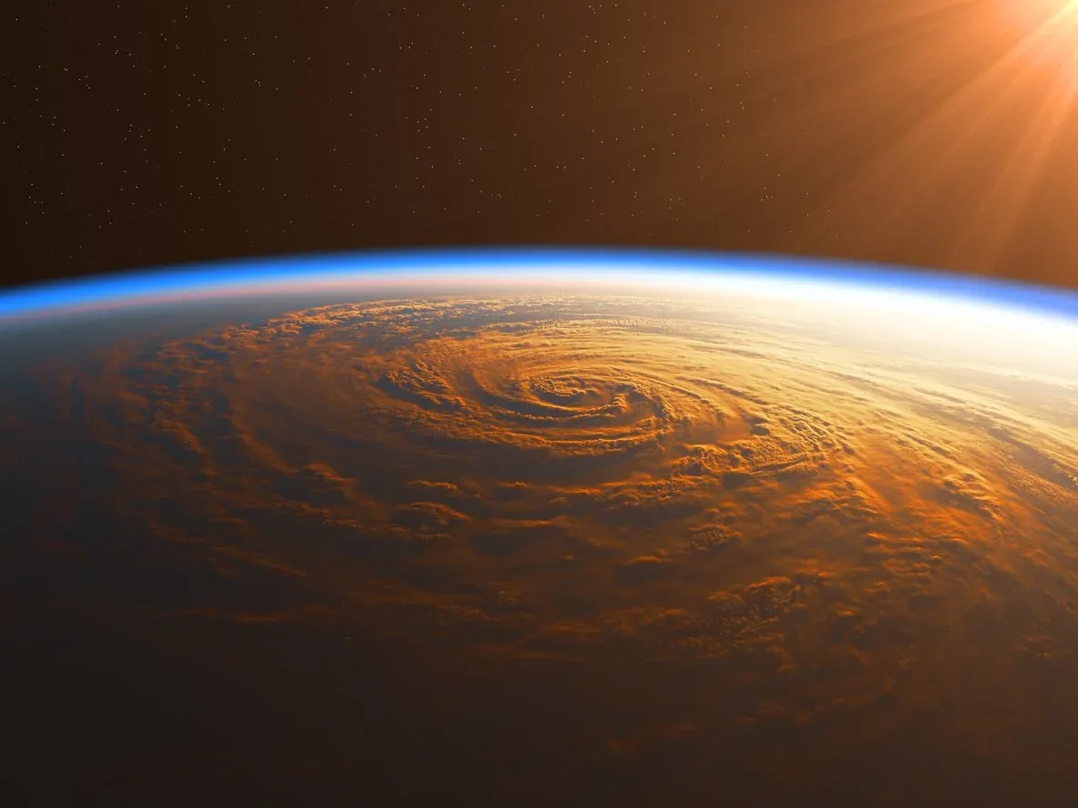View of Earth from space showing a hurricane with a swirling eye, illuminated by the sun.